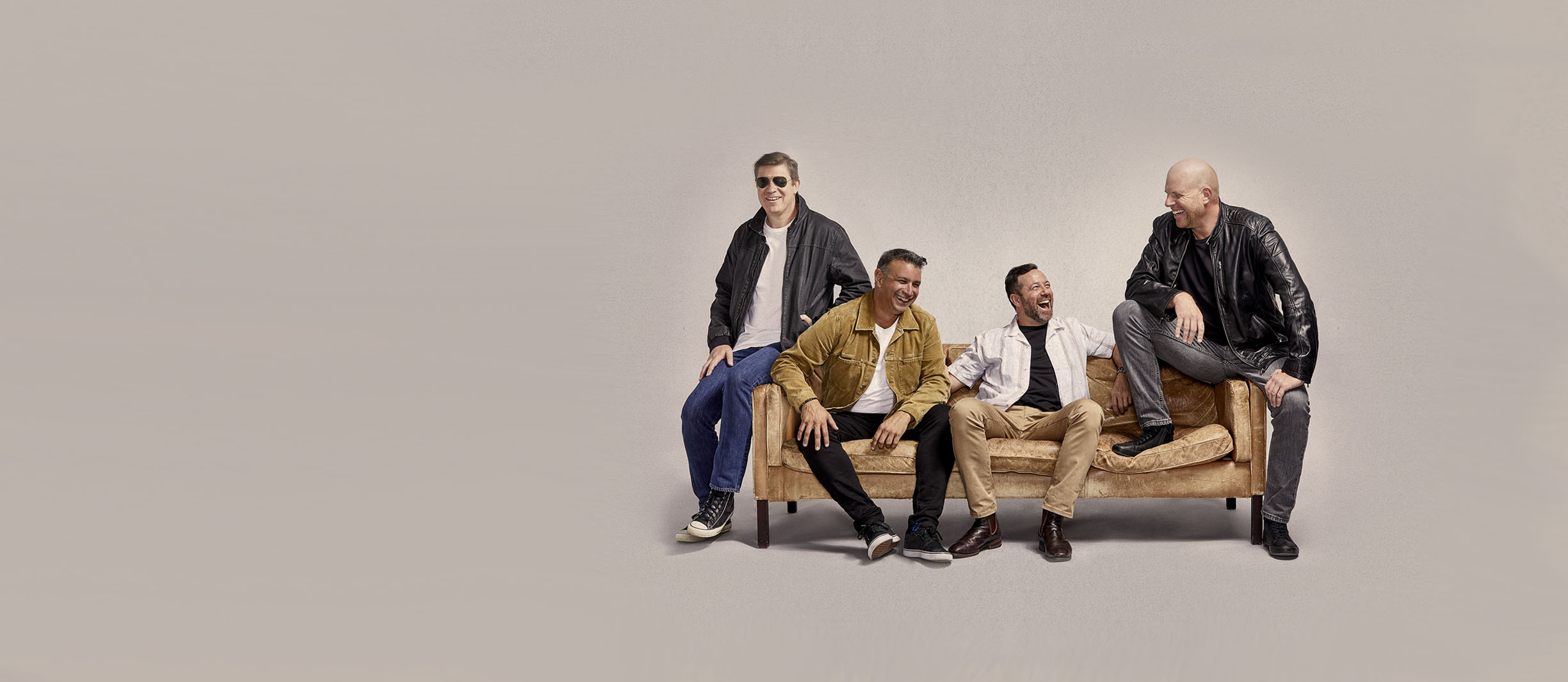 Comwire team wearing leather jackets sitting on a couch