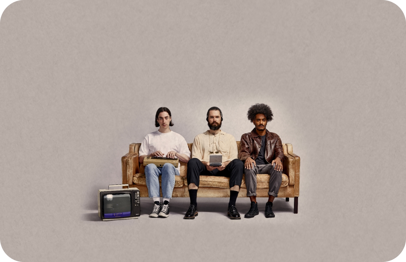 Group of people in older style fashion sitting on a leather couch